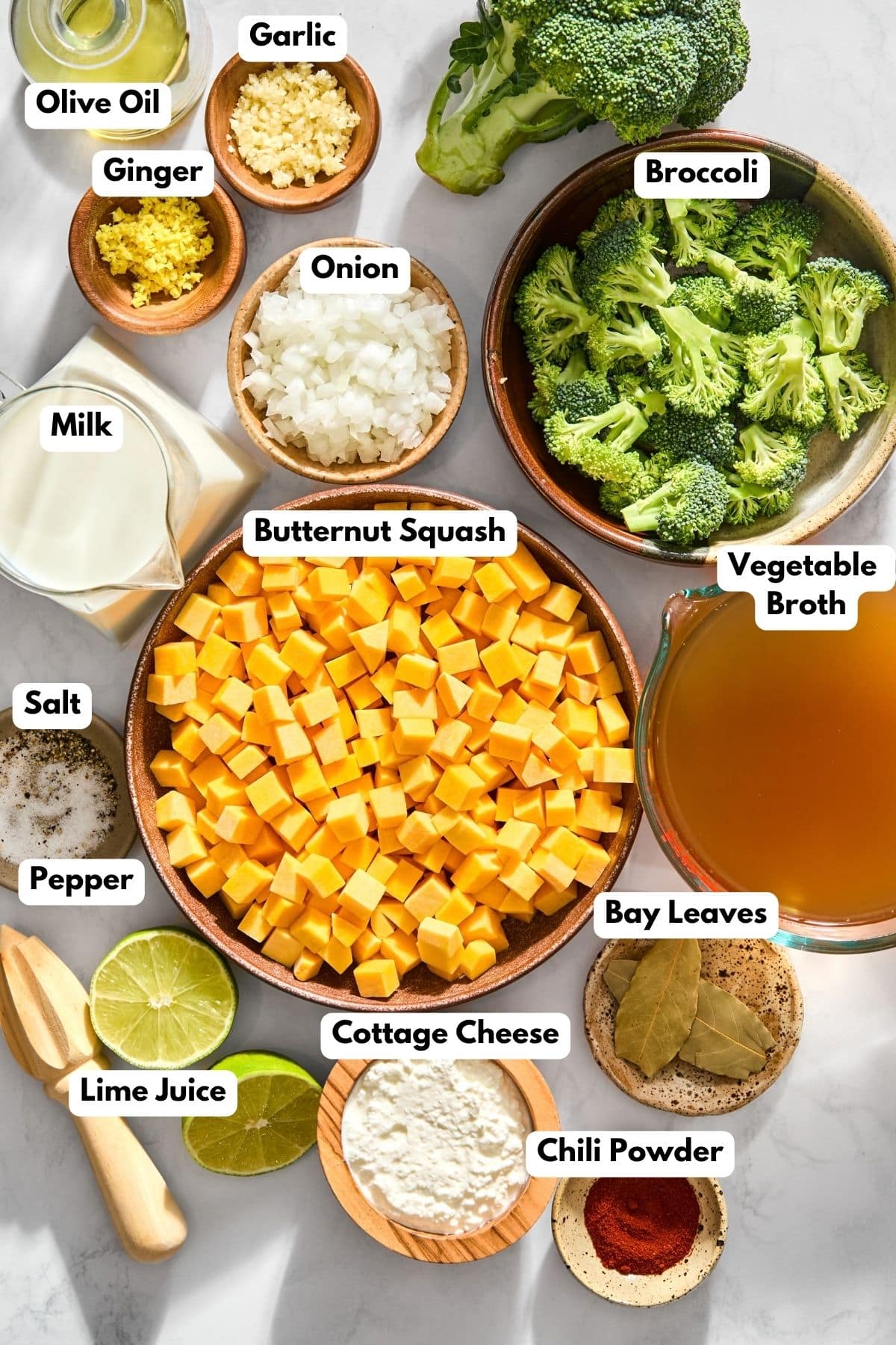 Ingredients to make this broccoli and butternut squash soup in bowls on a table.