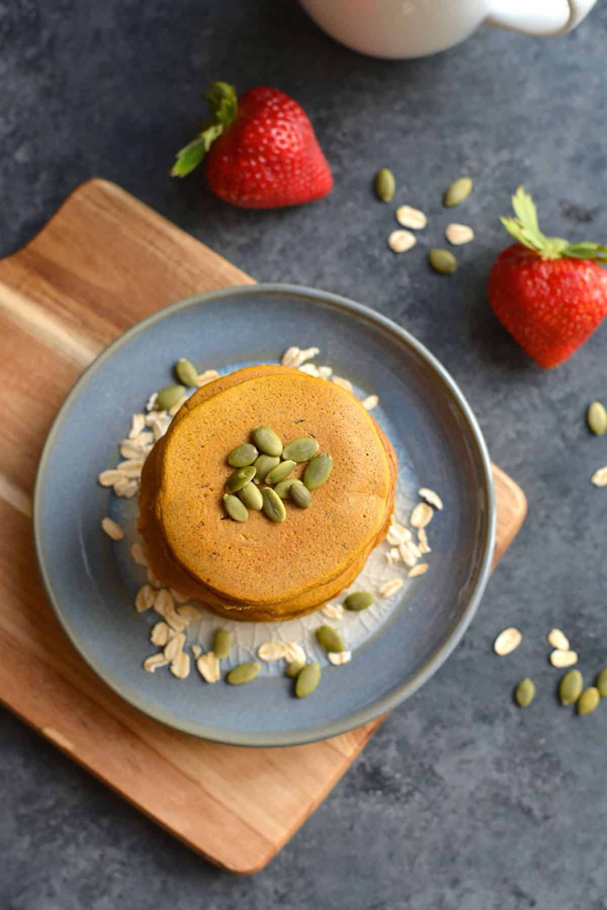 Pancakes with butternut squash inside with pumpkin seeds on top.