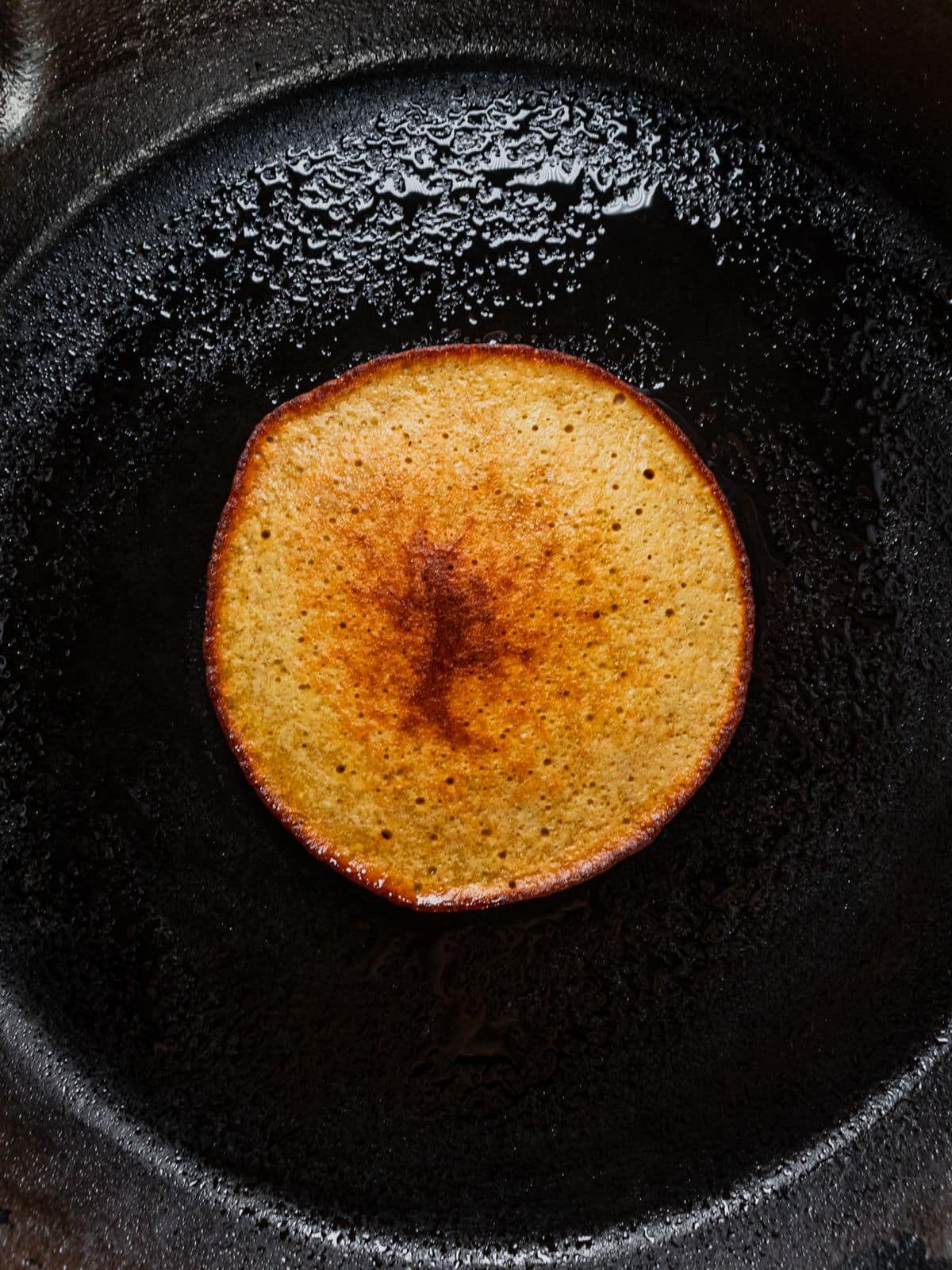 Pancake cooking on a skillet.